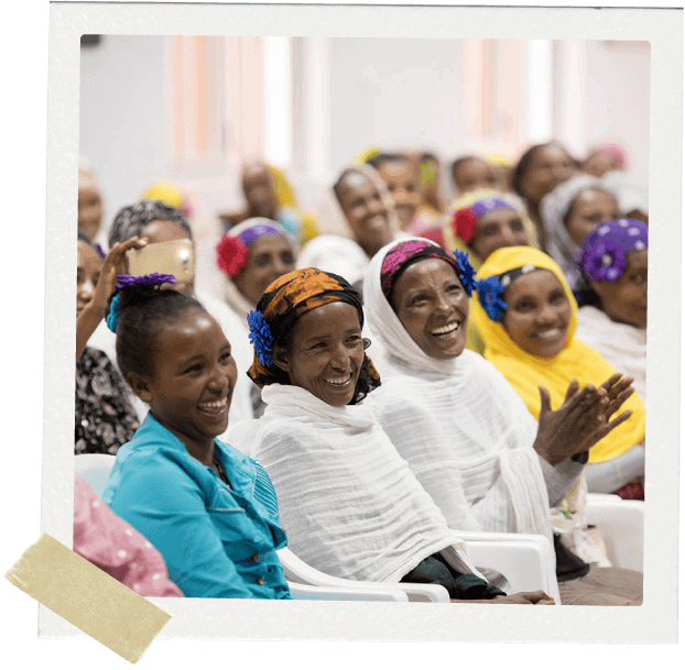 Women sitting in rows smiling and clapping