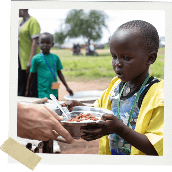 Small boy being handed plate and food