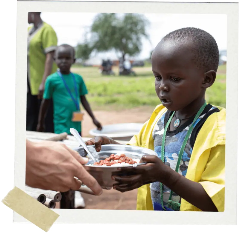 Small boy being handed plate and food