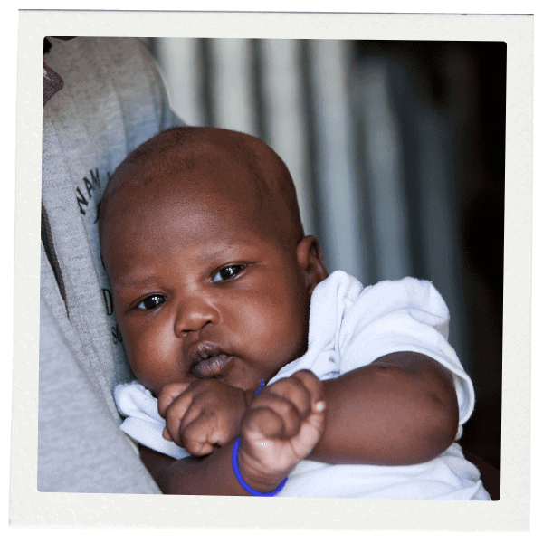 Baby with white shirt holding up hands